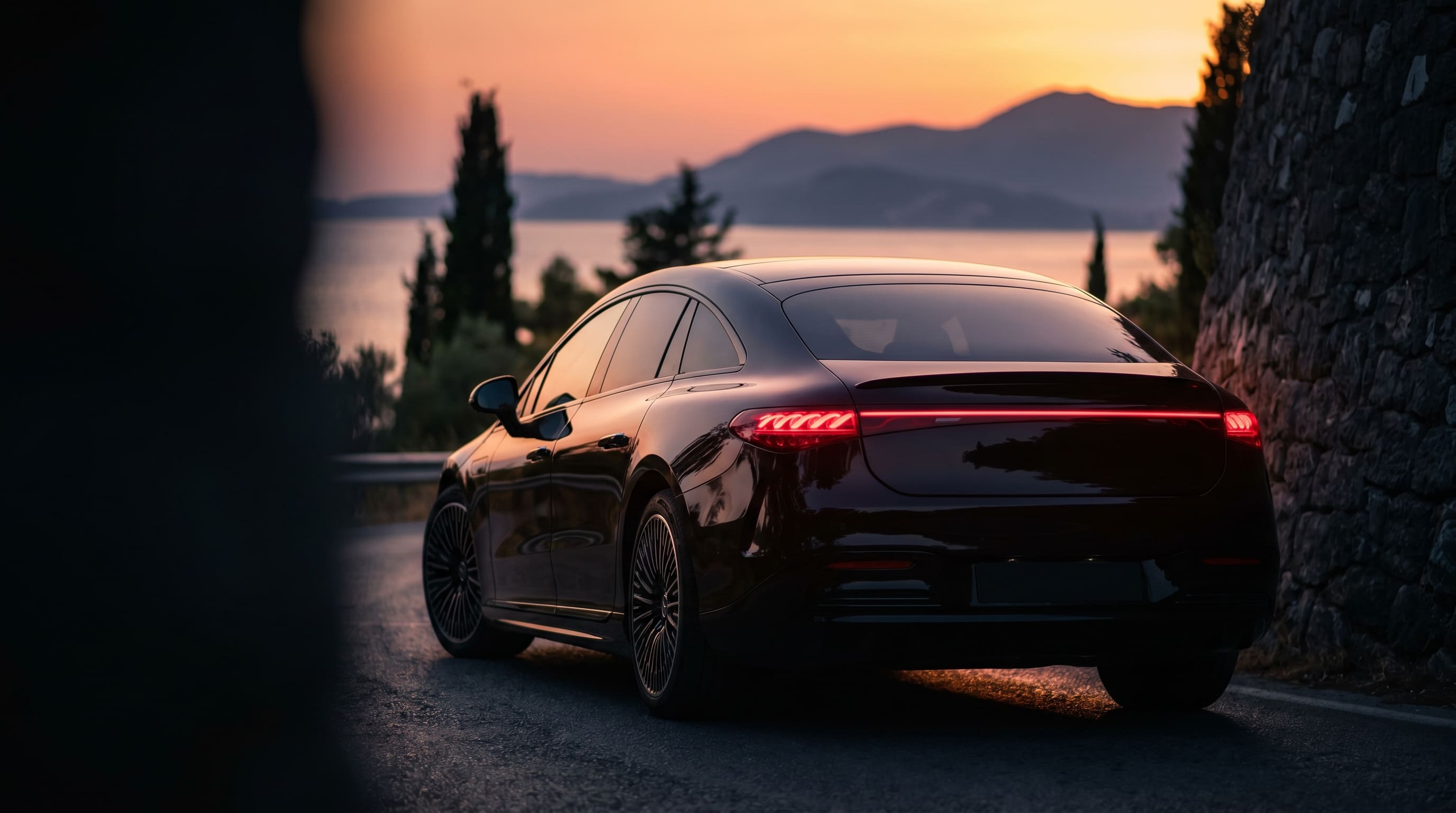 Modern sedan at sunset overlooking the Corfu coastline